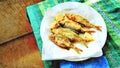 Watercolorstyle representing a plate of small fried fish with lemon ready to serve