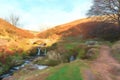 Digital watercolour of an autumnal waterfall and stone packhorse bridge at Three Shires Head in the Peak District. Royalty Free Stock Photo