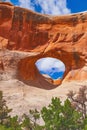 Digitally created watercolor painting of Tunnel Arch with a blue sky, Arches National Park.