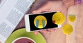 Digitally generated image of emojis flying over hand holding smart phone at table Royalty Free Stock Photo