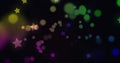 Digitally generated image of multi colored glowing spots and stars moving against black background Royalty Free Stock Photo