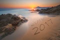 Digits 2016 and 2017 on coast sand at sunrise Royalty Free Stock Photo