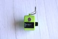 4 digits green tally counter or hand counter on the white wooden background