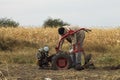 DIKANKA, UKRAINE - SEPTEMBER 30, 2015: Country farmer is plowing his garden with walk-behind garden tractor. Royalty Free Stock Photo