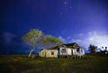 Dilapidated abandon wooden house at night with star and cloudy sky background