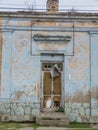 Dilapidated brick building situated in a bustling urban street, with a broken window a