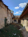 Dilapidated building facade. Cracked and pealed exterior plaster on brick wall and old window frames, no people Royalty Free Stock Photo