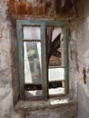 Dilapidated building facade. Cracked and pealed exterior plaster on brick wall and old window frames, no people Royalty Free Stock Photo