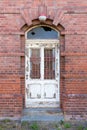 Dilapidated door in masonry house front