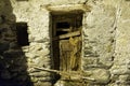 the dilapidated entrance of a chicken coop in an alpine hut