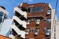 The dilapidated facade of multi-story building. Fire escape staircase outside the building, air conditioning on the wall