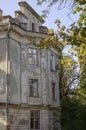 Dilapidated facade of an old building in an autumn park