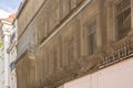 Dilapidated facade of an old house with net over it to protect pedestrians Royalty Free Stock Photo