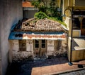 Dilapidated house with broken tile roof nestled between 3 buildings Royalty Free Stock Photo