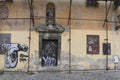 Dilapidated old and aged sacral baroque building. Scaffolding around walls, graffiti and faded plastering