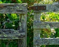 Dilapidated post and rail fence and gate covered in moss and lichens with a rusty iron hinge Royalty Free Stock Photo