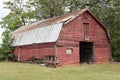 A dilapidated red barn survives in suburbia