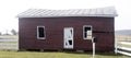 Dilapidated red outbuilding with metal roof