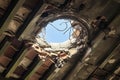 Dilapidated roof with gaping hole, offering a glimpse of sky