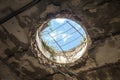 Dilapidated roof with gaping hole, offering a glimpse of sky