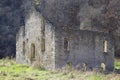 Dilapidated stone building in a field. Old mill in the fall. A stark background