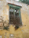 Dilapidated window in crumbling wall.