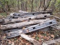 Dilapidated wood fence with holes in it and trees