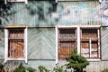 A dilapidated wooden abandoned house. Old building. Uninhabited house. The grating on the broken window. Realty Royalty Free Stock Photo