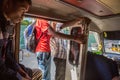 Teenage boy and other men inside a mikrolet bus driving with an open door, East Timor. Micro let minibus dangerous ride in capital