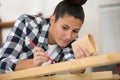 diligent female carpenter sanding wood at workshop Royalty Free Stock Photo