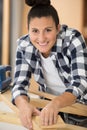 diligent female carpenter sanding wood at workshop