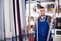 Young man worker examining plastic corners for tiles and floors Royalty Free Stock Photo