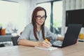 Diligent nerd university student writing notes at laptop Royalty Free Stock Photo