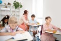 Diligent pupils listening to teacher and writing down words