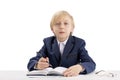 Diligent schoolboy sits at a desk with a pen and listens attentively to the teacher. First grader in class. Education concept