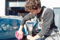 Diligent service man helping woman cleaning her car in commercial wash Royalty Free Stock Photo