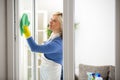 Diligent woman cleans window Royalty Free Stock Photo