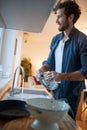 A diligent young man doing housework in the kitchen. Kitchen, housework, quarantin, home Royalty Free Stock Photo