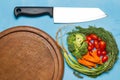 dill. baby tomatoes. carrot. broccoli. knife. on old chopping bo