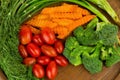 dill. baby tomatoes. carrot. broccoli. on old chopping borad woo