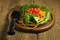 dill. baby tomatoes. carrot. broccoli. knife. on old chopping bo