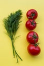 Dill and four tomatoes on yellow background Royalty Free Stock Photo