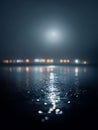 The Dim Moonlight Reflects on the Surface of a Misty Lake with Bokeh Lights Royalty Free Stock Photo