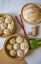Dim sum aka dumlings,momos in a traditional bamboo steamer, with red chopsticks, Chinese cabbage & ginger root