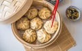 Dim sum aka dumplings,momos in a traditional bamboo steamer, with red chopsticks, Chinese cabbage