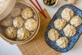 Dim sum aka dumplings,momos in a traditional bamboo steamer, with red chopsticks, Chinese cabbage Royalty Free Stock Photo