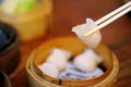 Dim Sum or Har Gow dumplings was picked by chopsticks from a Bamboo steamer basket. Close up Ha Gow, popular appetizer