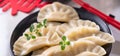 Dim sum. Homemade Chinese dumplings are served on a black plate. They eat with chopsticks. Oriental cuisine, light Royalty Free Stock Photo