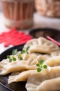 Dim sum. Homemade Chinese dumplings are served on a black plate. They eat with chopsticks. Oriental cuisine, light Royalty Free Stock Photo