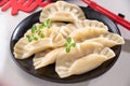 Dim sum. Homemade Chinese dumplings are served on a black plate. They eat with chopsticks. Oriental cuisine, light Royalty Free Stock Photo